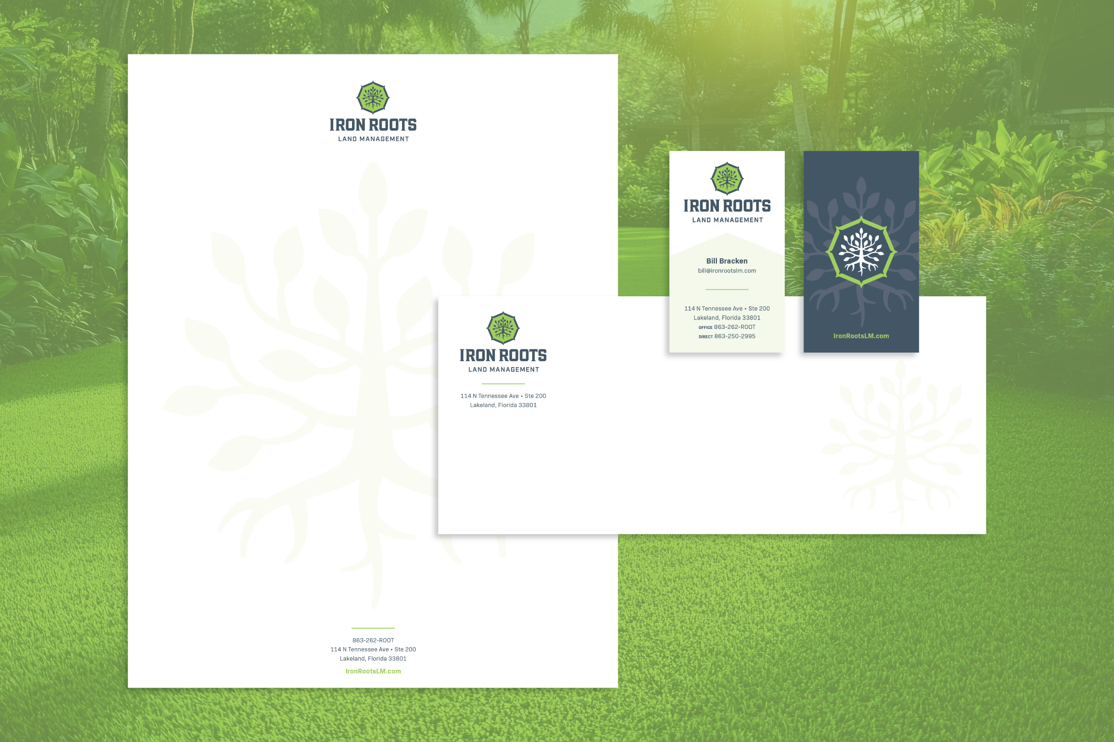Iron Roots Land Management stationery mockup on a green foliage background: a letterhead with a faint tree-root watermark and contact info, a matching envelope, and a business card set (front listing Bill Bracken's contact details and a dark navy back with a large white root icon), all featuring the hexagonal tree/root logo.